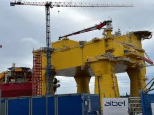 A floating offshore oil production vessel and an offshore wind converter platform sit in the Aibel yard in Haugesund,